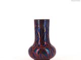 a blue and red vase sitting on a white surface
