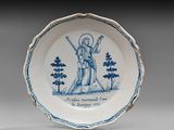 une vieille assiette bleue et blanche sur laquelle figure l'image d'un homme tenant une épée