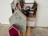 a woman that is sitting on a pallet in front of a house