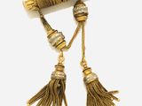 a close up of a pair of tassels on a white surface