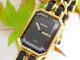 a black and gold watch with a chain around it