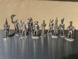 silver figurines of soldiers with spears and shields on a table