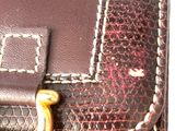 a close up of a brown purse with a gold ring on it