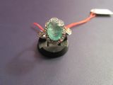une bague ornée d'une pierre verte, montée sur un cordon rouge
