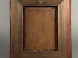 an old wooden frame with a small square hole in the middle