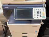 une imprimante multifonction posée sur une pile de fournitures de bureau