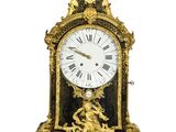 a gold clock with an angel on top of it