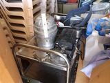 un chariot métallique sur lequel est posé un mixeur, dans une pièce encombrée