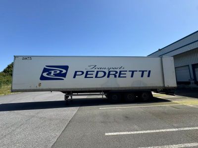 un semi-remorque garé devant un immeuble