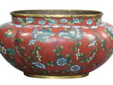 un vase rouge orné de fleurs bleues sur fond blanc