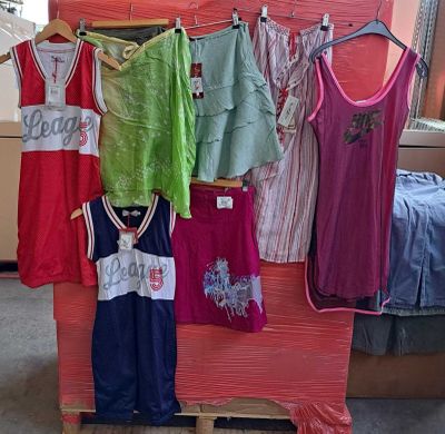 une présentation de vêtements suspendus à un portant dans une pièce