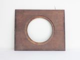 an old wooden frame with a hole in it on a white surface