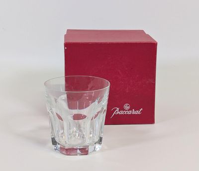 une boîte rouge et un verre posés sur une surface blanche