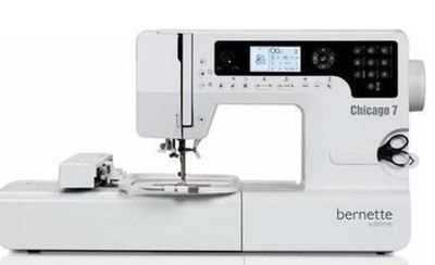 La machine à coudre est posée sur une table blanche.