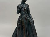 statue en bronze représentant une femme en robe et avec un chapeau