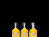 three bottles of perfume on a black background