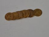 a pile of coins sitting on a table next to a cell phone