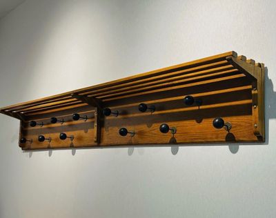 une étagère en bois sur laquelle sont fixés plusieurs boutons noirs