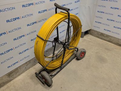 un tuyau jaune posé sur un chariot près d'un mur
