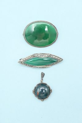 three pieces of jewelry including a broochle, a pendant and a broochele