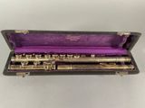 a flute in a case with a purple cloth inside