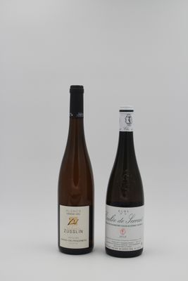 deux bouteilles de vin posées l'une à côté de l'autre sur une surface blanche
