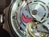 a close up of a watch on a wooden table