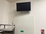 une photo d'une chambre d'hôpital avec une télévision accrochée au mur