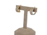 pair of gold and diamond hoop earrings on display stand