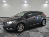La voiture grise est garée dans le garage, sur le sol à damier.