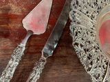 a silver plate with a knife and a piece of cake on it