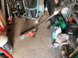 a man that is standing in a garage with a baseball bat