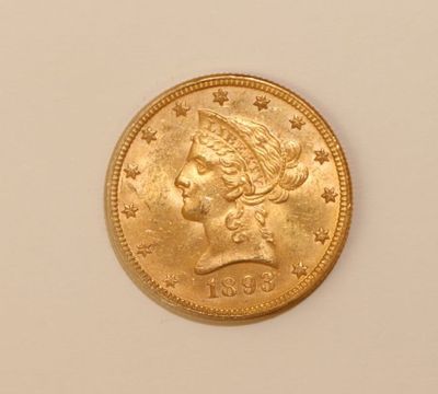 a close up of a gold coin on a white surface
