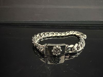 bracelet en argent orné d'un crâne et d'une croix sur un fond noir