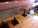 des tables et des bancs dans un restaurant au sol et aux murs en bois