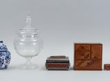 un bocal en verre, une boîte et une boîte d'allumettes posés sur une surface blanche