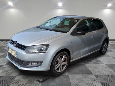 the silver volkswagen polo is parked in a room with a checkered floor