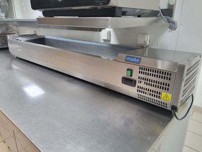 plan de travail en acier inoxydable dans une cuisine professionnelle, sur lequel est posé un téléviseur