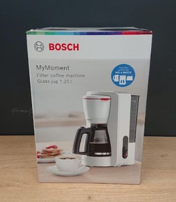 une cafetière dans son emballage, posée sur une table à côté d'une tasse de café