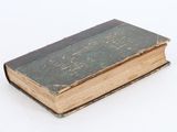 an old book sitting on top of a white table