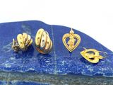 un gros plan sur trois paires de boucles d'oreilles en or posées sur une pierre bleue