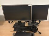 deux écrans d'ordinateur et un clavier posés sur le bureau
