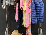 clothes hanging on a rack with a hat on top of it