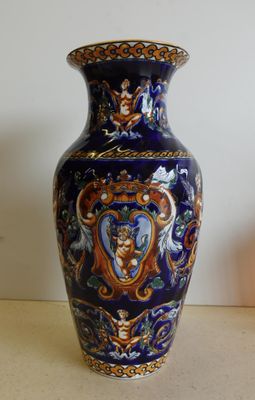 un vase bleu posé sur une table à côté d'une bougie
