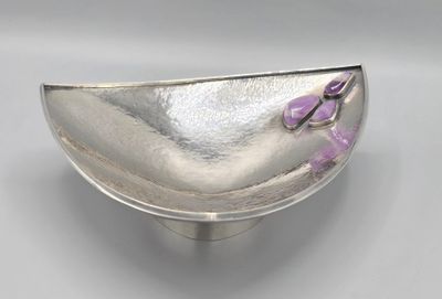 assiette en argent ornée d'une fleur violette sur un fond gris