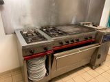 two stoves in the kitchen with plates stacked on top of them
