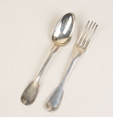 deux cuillères et une fourchette en argent sur une table