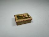 a small box with a painting on it on a table