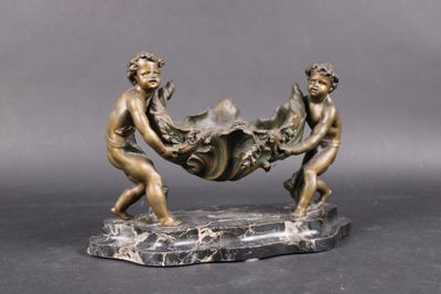a bronze sculpture of two men carrying a large object