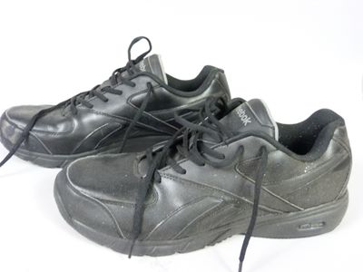 une paire de chaussures noires posées sur une surface blanche